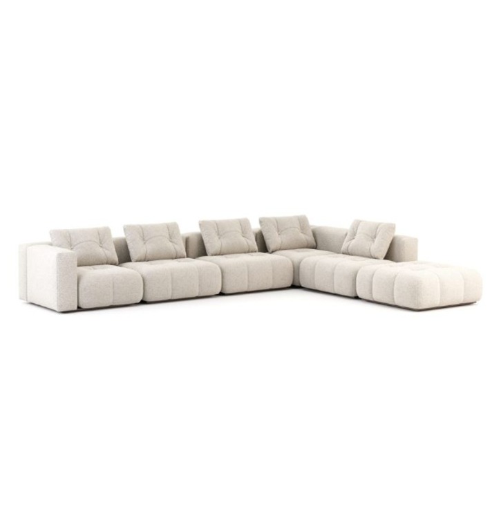 Il divano Antónia è mostrato su uno sfondo bianco come un ampio modulo a L rivestito in bouclé crema, con cuscini profondamente trapuntati e una base bassa e discreta che ne evidenzia i volumi scultorei e la silhouette generosa e architettonica.