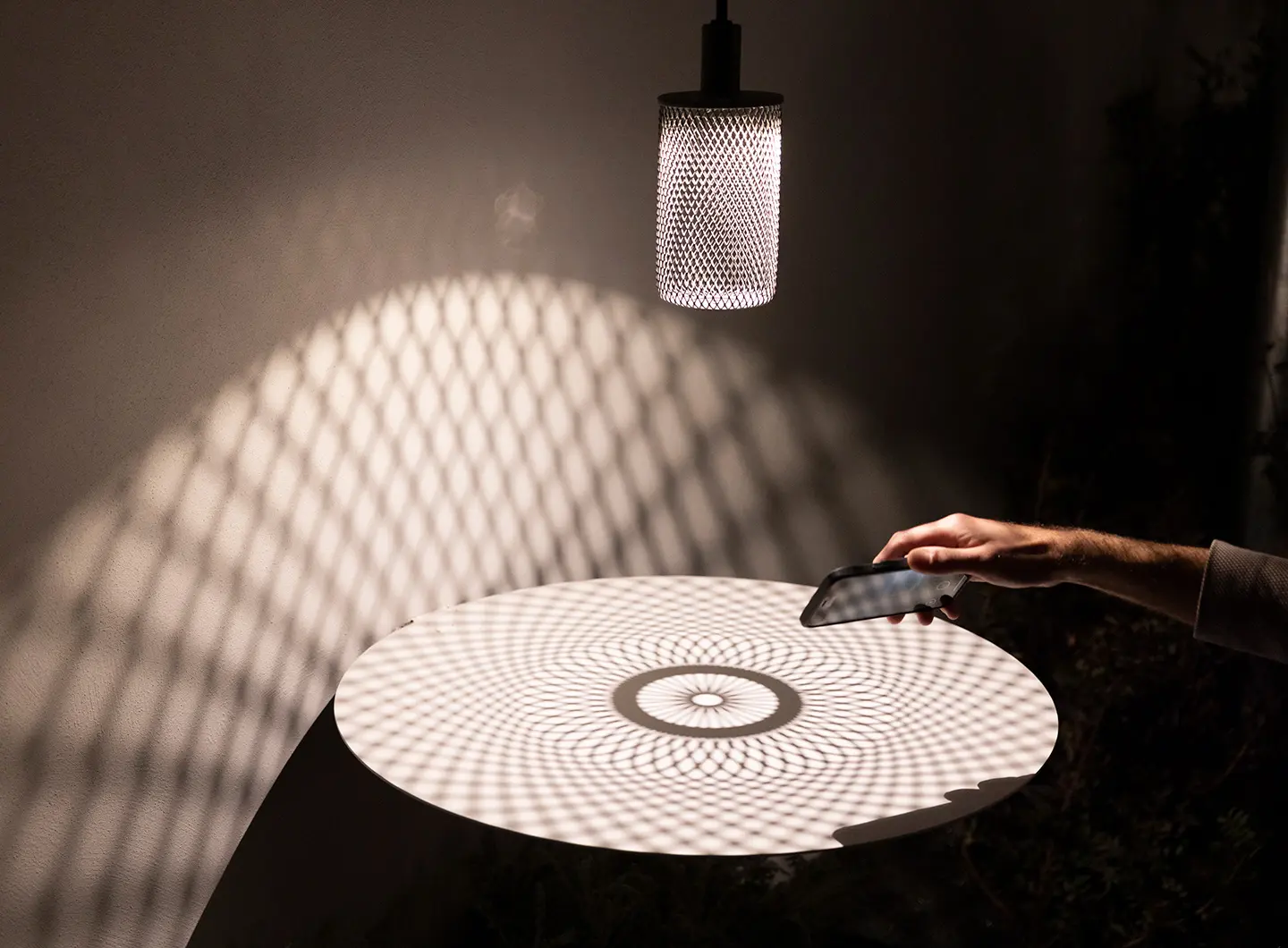 Outdoor lamp with perforated steel structure that creates pattern