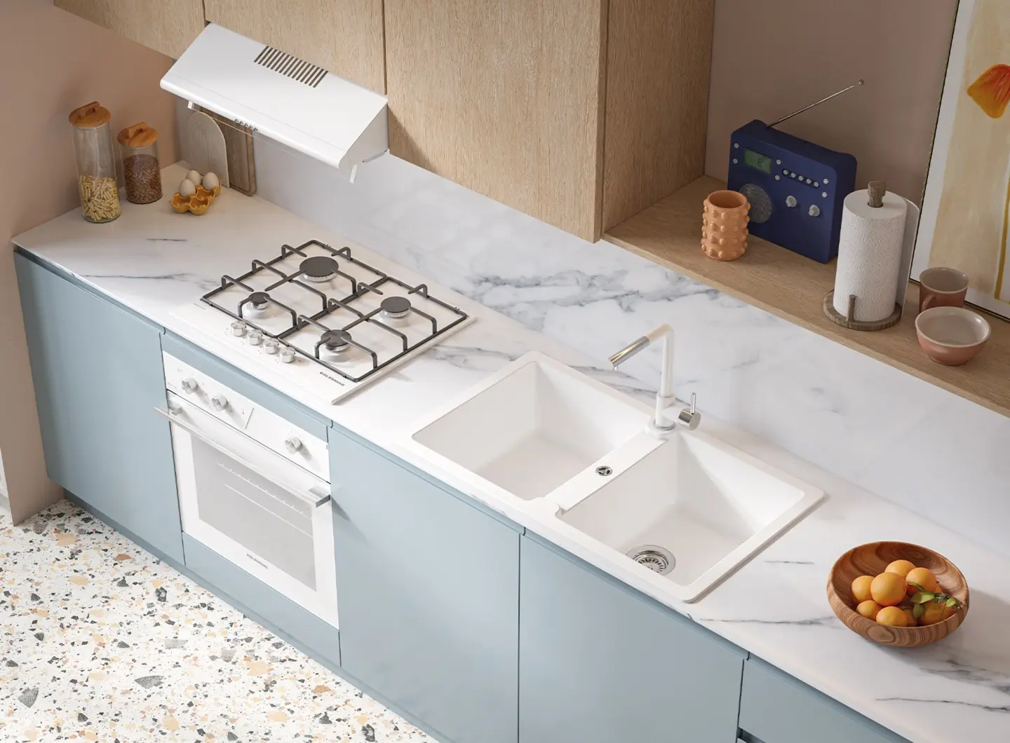 Cucina luminosa dallo stile giovane e fresco, caratterizzata da basi color carta da zucchero e pensili in legno chiaro. Il piano di lavoro in marmo bianco con venature grigie ospita un lavello bianco a doppia vasca con miscelatore coordinato bianco opaco e un piano cottura a gas bianco. Un forno da incasso bianco è perfettamente integrato sotto i fuochi, mantenendo una continuità cromatica pulita ed essenziale.