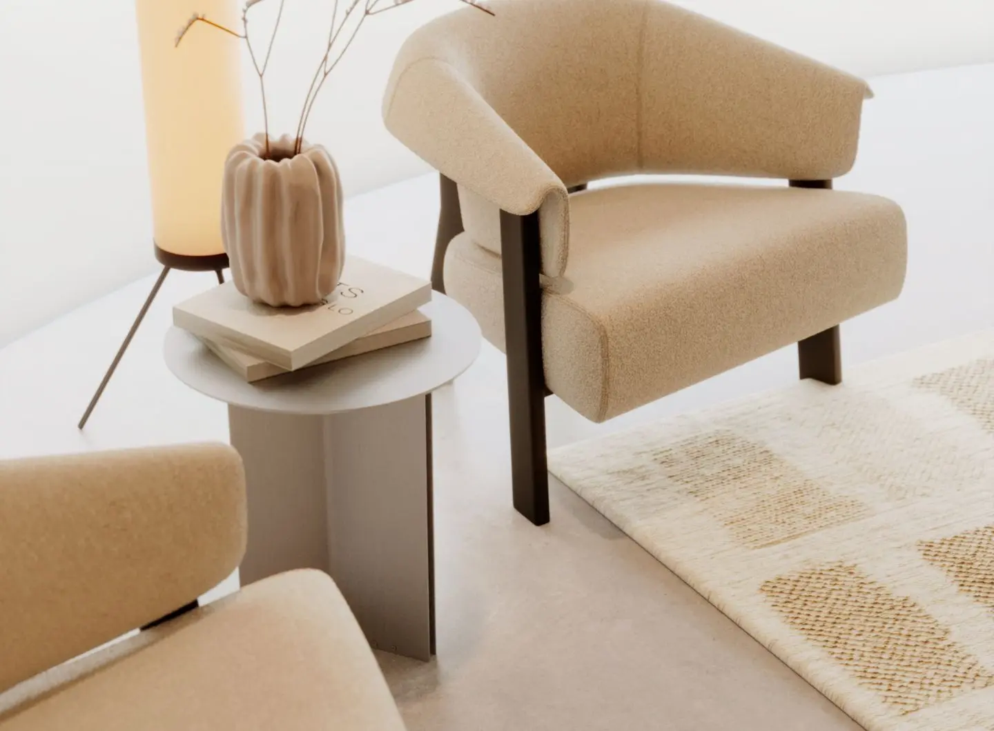 Il tavolino Steel è mostrato tra due poltrone beige come un tavolino rotondo in acciaio con piano grigio chiaro e base a pannelli verticali, con libri impilati e un vaso scultoreo sotto una lampada calda, aggiungendo un tocco calmo e raffinato all’angolo minimalista.