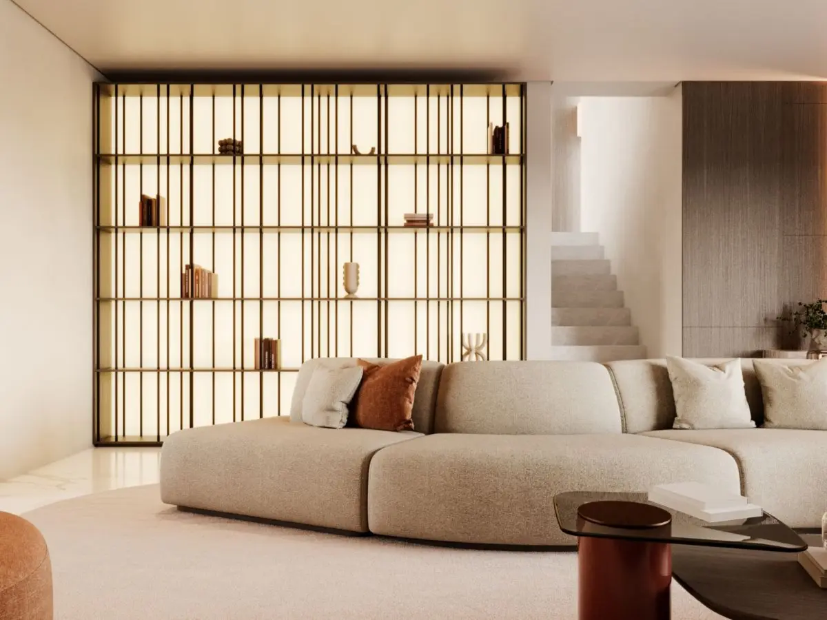 La libreria Buren appare come una struttura retroilluminata con montanti verticali sottili e luce calda, posizionata dietro un divano curvo beige e decorata con pochi oggetti, diventando un punto focale architettonico che porta ordine ed eleganza silenziosa all’ambiente.