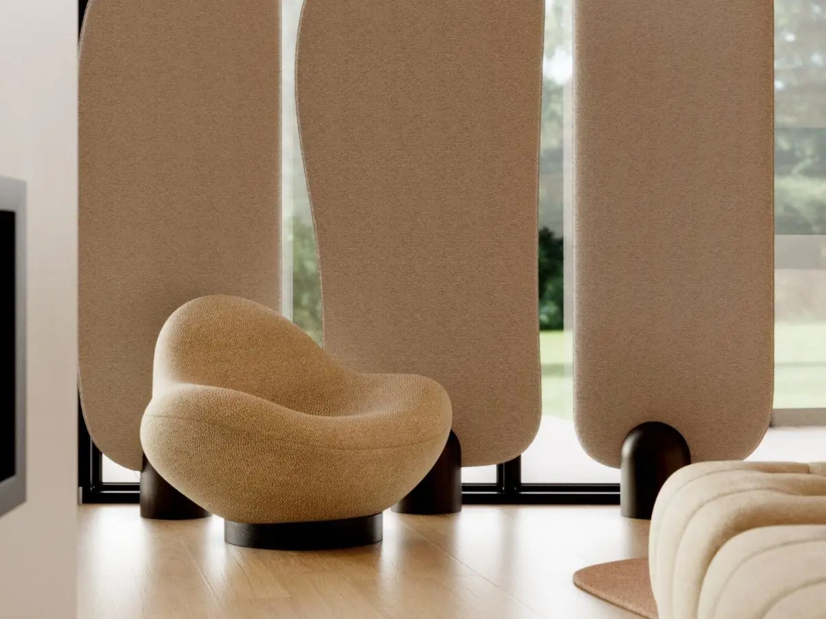 La poltrona Stone, con la sua silhouette arrotondata e organica e il rivestimento beige a trama, poggia su una base circolare scura in una stanza minimalista, dove alti pannelli curvi filtrano la luce naturale e lasciano intravedere il verde all'esterno.