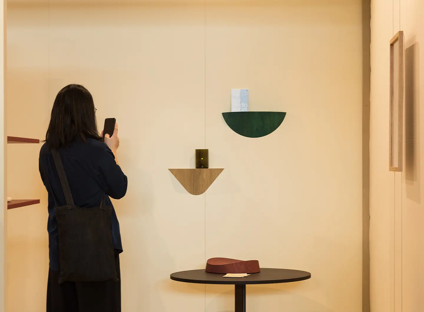 Girl taking photos at wooden coffee table and shelves