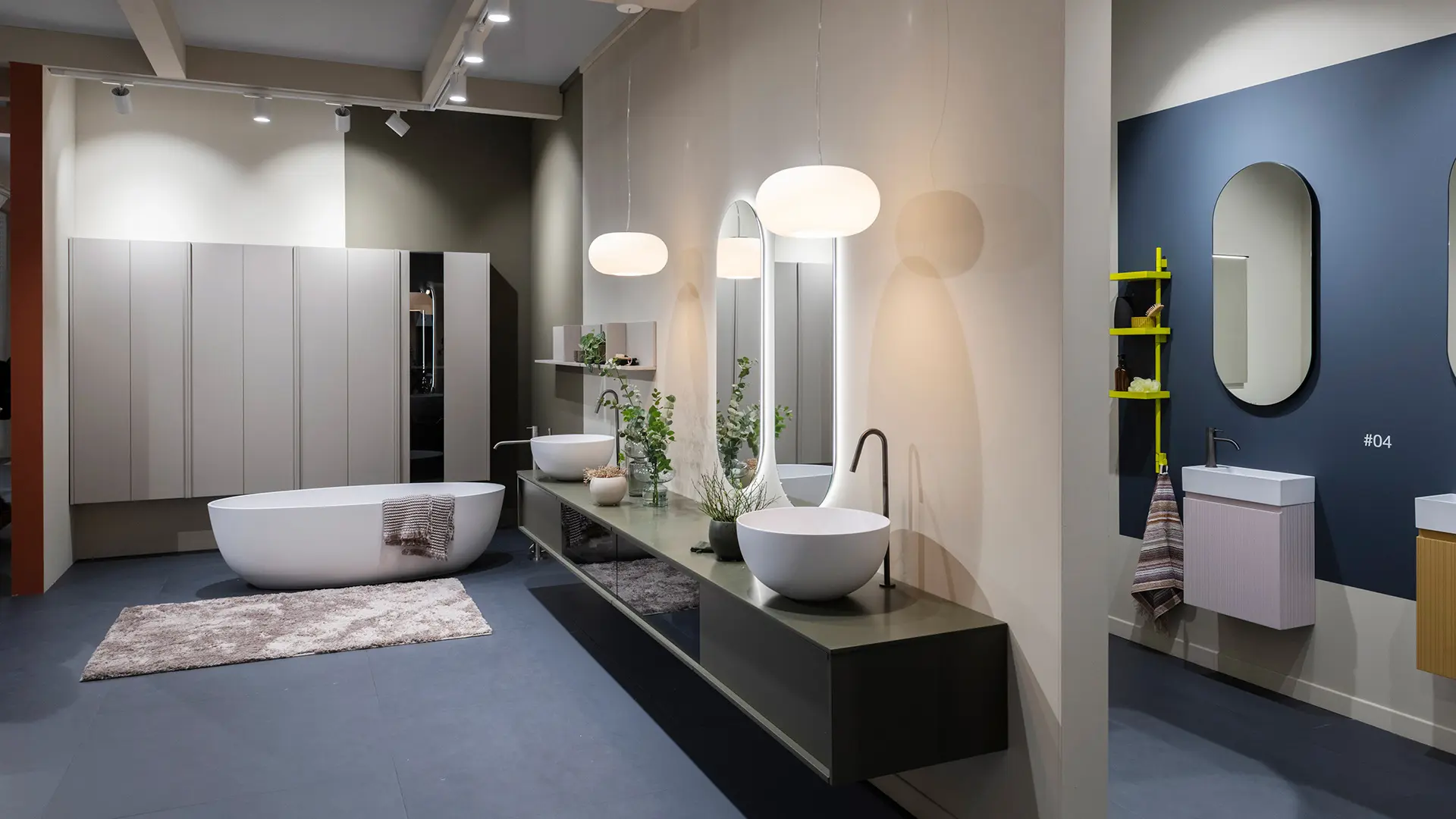 bathroom with freestanding oval bathtub,  suspended bathroom furniture,  sit-on basin and two oval mirror on the wall